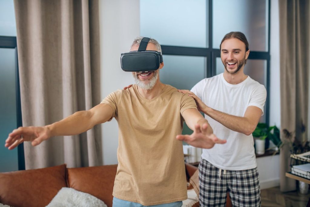 Man in vr glasses walking in the room, his partner supporting him