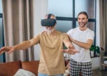Man in vr glasses walking in the room, his partner supporting him
