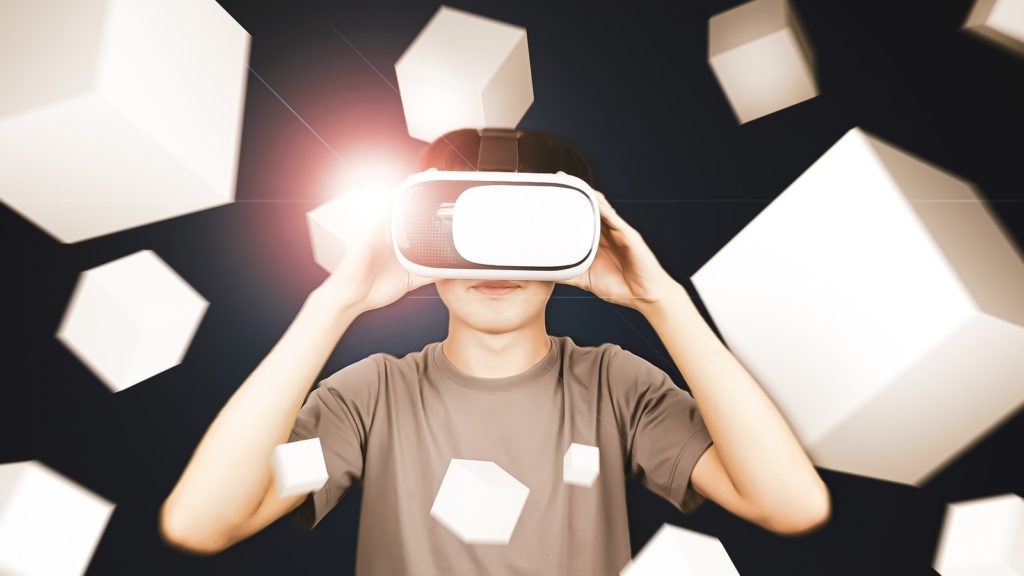 Man wearing glasses of virtual reality headset (VR) using with smartphone and playing box game.