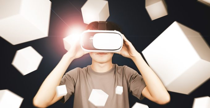 Man wearing glasses of virtual reality headset (VR) using with smartphone and playing box game.