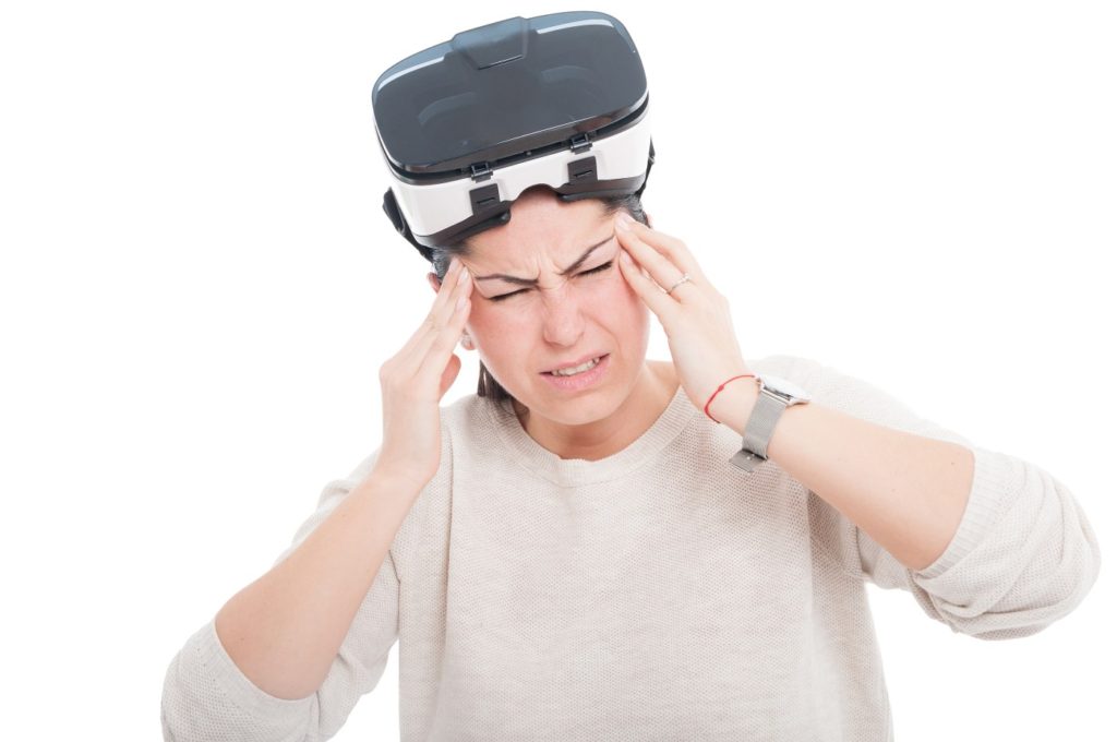 Young female looking exhausted or tired after using VR headset isolated on white background